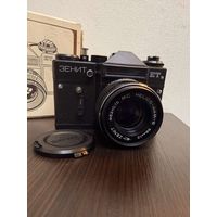 Винтажный советский фотоаппарат Зенит -ЕТ оснащен объективом МС Helios-44M6 с фокусным расстоянием 58мм и светосилой 1:2  в коробке с документами .