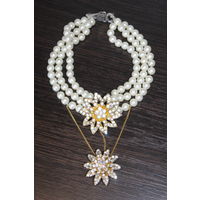 Пластиковое, многослойное колье с двумя подвесками в форме цветов.